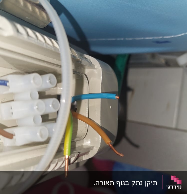 חוטי חשמל צבעוניים מחוברים לקופסת חיבורים